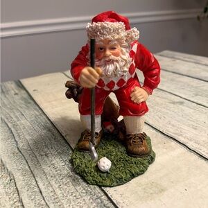 Santa Clause figurine golfer golf lining to putt.